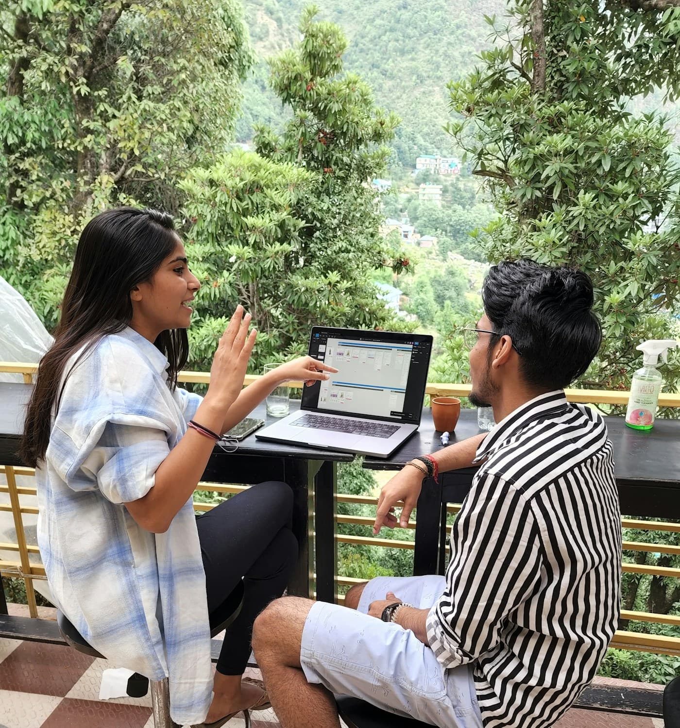 Two young adults discussing a plan on a laptop